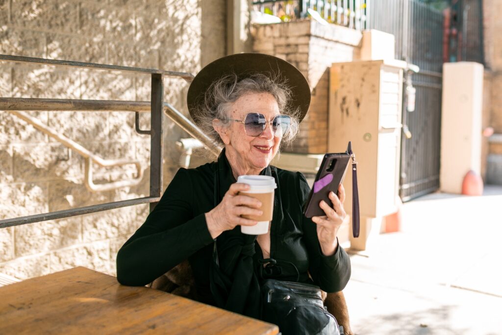 older woman drinking coffee on phone